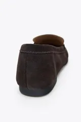 Zapato mocasín de mujer color marrón oscuro, confeccionado en serraje con detalle de tira en la parte delantera y acabado en punta redonda.