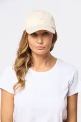 Gorro con visera color beige, confeccionado en lona de algodón y con bordado frontal.