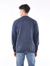 Campera tejida azul melange con cierre frontal y bolsillos laterales.