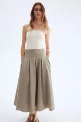 Pollera tobillera color beige con textura de lino, de tiro alto con cierre oculto y cierre de corchete atrás. Pinzas en la parte superior para crear una elegante y favorecedora silueta evasé. Forrada.