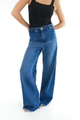 Pantalón de jean azul de corte wide leg con terminación desflecada.
