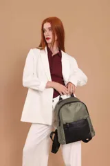 Mochila urbana color gris con detalles en cuero sintético negro. Cuenta con un compartimento principal amplio y un bolsillo frontal con cierre.