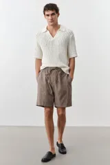 Short marrón claro en tejido liviano de lino y algodón. Modelo con elástico revestido y cordón para ajustar en la cintura, cierre con botón, bolsillos laterales y bolsillo insertado atrás.