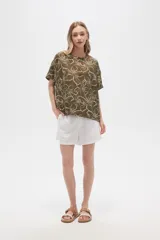 Blusa verde militar con estampado de flores blancas, de viscosa, corte holgado, cuello redondo y mangas cortas.