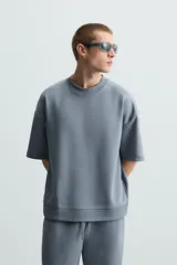 Sudadera relaxed fit color crudo confeccionada en tejido interlock de algodón con elasticidad, cuello redondo, manga corta y bajo acabado en rib.