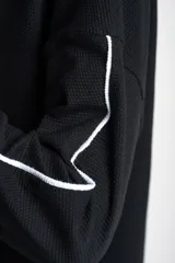 Sweater negro de algodón peinado con elastano, corte oversize y mangas largas con rayas blancas en los brazos.