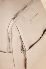 Mochila negra de cuero sintético con diseño minimalista, formato compacto y estructura blanda. Incluye bolsillo delantero con broche y cierre metálico superior con tiradores largos.