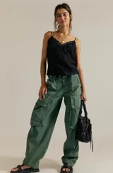Pantalón cargo de inspiración utilitaria, color verde militar, con calce holgado en toda la pierna y tiro medio. Presenta grandes bolsillos utilitarios con tapa y detalles de costuras visibles.