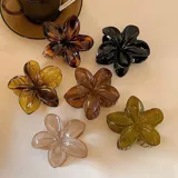 Pinza de cabello negra en forma de flor, elaborada a mano.