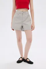 Short de jean color beige, de tiro alto y corte holgado.