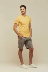 Remera celeste con estampado de figuras geométricas en tonos naranja y verde.