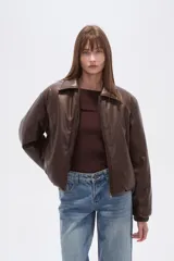 Campera estilo bomber de eco-cuero color marrón oscuro, con cuello camisero, cierre frontal y puños y cintura ajustados.