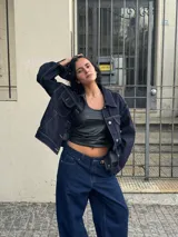 Campera de jean azul oscuro con costuras en hilo ocre, corte recto, cuello clásico, bolsillos frontales con solapa y cierre con botones metálicos.