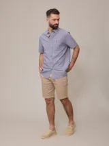 Camisa de manga corta con rayas verticales azules y blancas, confeccionada en algodón.