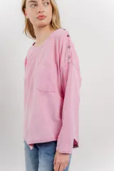 Remera celeste de manga larga con cuello redondo y bolsillo en el pecho.