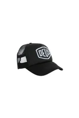 Gorra negra tipo trucker de la marca Deus Ex Machina, con paneles frontales rígidos, visera curva y paneles traseros de malla. Presenta un parche con el logo de la marca en blanco y negro en el frente.