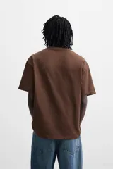 Camiseta blanca de algodón compacto, corte relaxed fit, cuello redondo y mangas cortas.