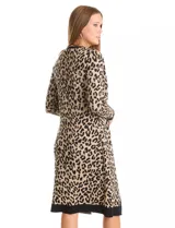 Vestido de tejido de punto marca Nina Leonard, con diseño Twofold que simula un conjunto de vestido negro liso y cárdigan largo con estampado geométrico blanco y negro. Presenta escote redondo y manga larga de corte recto.