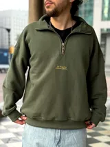 Buzo verde militar de felpa con frisa gruesa, corte boxy, medio cierre con cremallera y estampado minimalista con la frase "The Wise Club Exclusive Members".