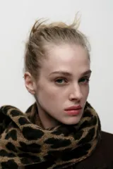 Bufanda rectangular color marrón con estampado de leopardo y flecos cortos en los extremos.