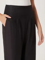 Pantalón de vestir color naranja, de corte recto y tiro alto, con pinzas en la cintura.