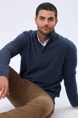 Buzo tejido texturado color azul marino, con cuello alto y botones frontales.