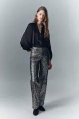 Pantalón oxford de cuero ovino con estampado reptil multicolor y detalles metalizados. Tiro alto, cinco bolsillos y pierna ancha desde la cadera.