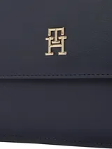 Cartera mensajera Tommy Hilfiger azul marino con monograma TH, asa superior, correa de textil trenzado ajustable y extraíble, bolsillo interior con cremallera, monedero extraíble con cremallera y detalles distintivos de la marca.