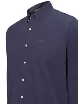 Camisa de hombre de manga larga, color azul marino, confeccionada en cotelé de algodón orgánico. Tiene cuello camisero, cierre con botones y bolsillo en el pecho.