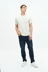 Jean slim azul oscuro, tiro medio, con pasacintos y confeccionado en 98% algodón y 2% spandex.