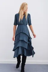 Vestido azul petróleo con escote en V, largo midi, mangas cortas, elástico en la cintura y falda con volados en capas.