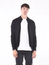 Campera negra con cierre frontal, cuello alto y puños con ribete celeste.