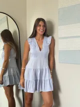 Vestido corto lila con escote en V, volados en los hombros y falda con dos niveles de volados.