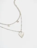Collar corto plateado de doble cadena, con dije de corazón y chapitas circulares.
