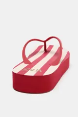 Sandalias tipo ojotas rojas con plataforma y estampado de rayas horizontales blancas en la plantilla.