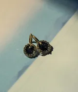 Par de aros dorados con dije circular de resina color terracota con glitter y borde de strass.