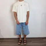 Remera blanca de corte clásico con estampado en la espalda que incluye un óvalo con diseño abstracto y la frase "BREATHEfast Feel the Vcp Concept Drift".