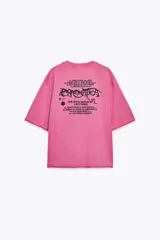 Camiseta rosa de algodón con efecto lavado, cuello redondo y manga corta. Estampado frontal con el texto "GAGA" en color negro.