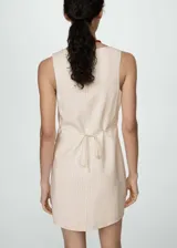 Vestido corto color crema con finas rayas verticales, escote cuadrado, tirantes anchos y cierre frontal con botones.