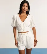 Short corto de laise de algodón con cintura fija, trabillas con abalorios, cierre tradicional, pliegues y estampa floral.