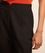 Pantalón de vestir negro de corte recto, con bolsillos laterales y cierre de cremallera lateral. Presenta detalles de hilo metalizado en la trama.