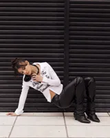 Bota de cuero negro con caña corta arrugada y taco fino.