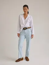 Remera blanca de algodón con cuello en V y volados de lino.