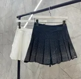 Minifalda tableada negra con short incorporado y strass plateados.