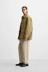 Pantalón de hombre color beige, corte carrot fit, con cintura elástica ajustable con cordón, bolsillos frontales y bolsillo trasero de plastrón.