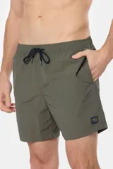 Short de baño azul vibrante, de corte clásico y largo medio, con cintura elástica y cordón ajustable. Cuenta con bolsillos laterales y suspensor de malla fina interior.