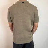 Chomba color marrón claro de tejido de punto con cuello polo y mangas cortas.