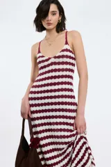 Vestido largo de punto con rayas horizontales blancas y negras, breteles finos y falda acampanada.