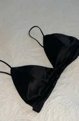 Top negro de satén con breteles finos y escote triangular.