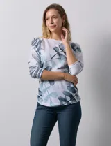 Buzo blanco con estampado de hojas en tonos azulados, de cuello redondo y mangas 3/4.